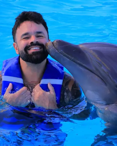 Justin being kissed by a dolphin